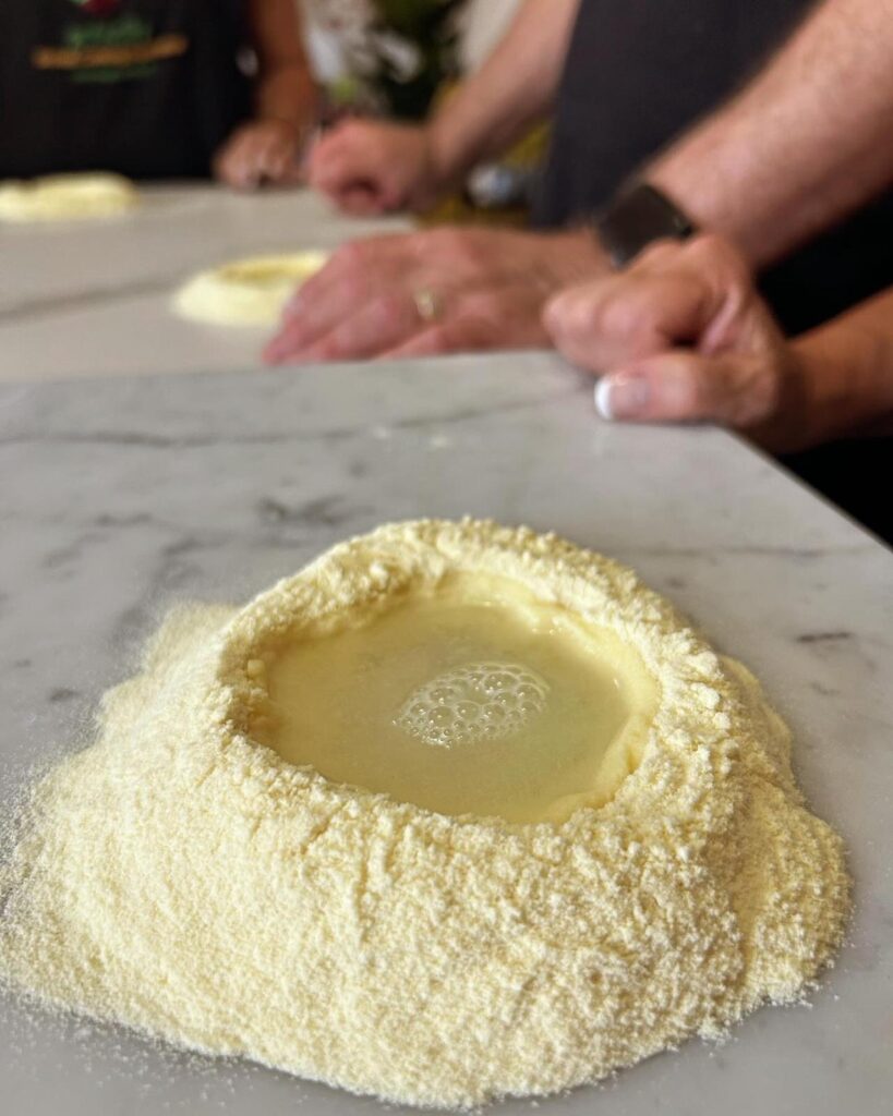 A pile of semolina flour with water is waiting to become pasta on a Sicilian countertop