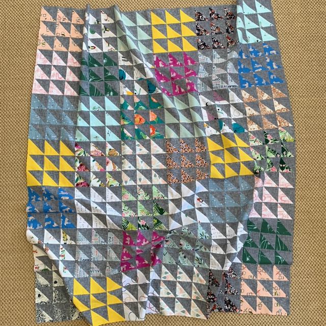 a quilt top made of half square triangles on a floor