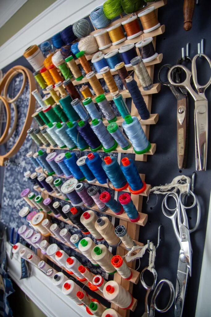 An assortment of threads in mostly blue tones sit on a thread holder