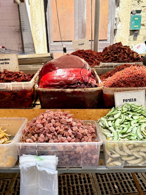 Estratto sits in a bin amongst other tomato products in a market in Sicily